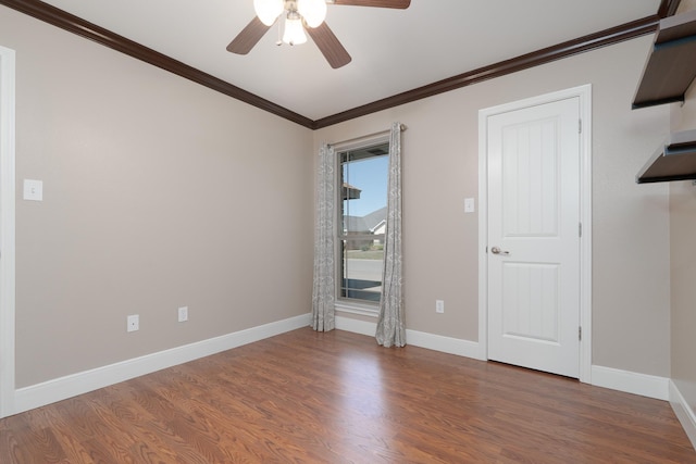 empty room with ceiling fan, baseboards, wood finished floors, and ornamental molding