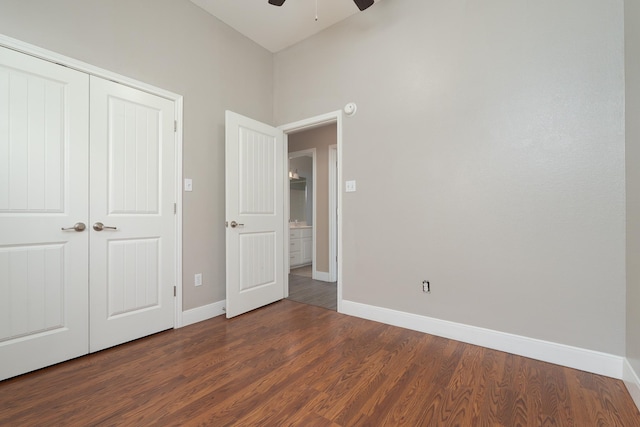unfurnished bedroom with a closet, baseboards, ceiling fan, and dark wood-style floors