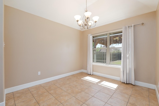 spare room with baseboards, a notable chandelier, and light tile patterned flooring