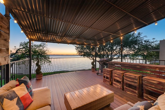 deck at dusk with an outdoor hangout area and a water view