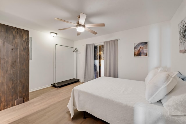bedroom with light wood finished floors, baseboards, and a ceiling fan