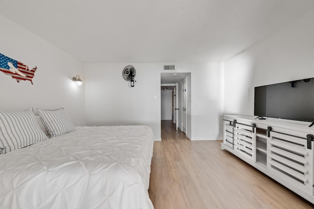 bedroom with baseboards, light wood-style floors, and visible vents