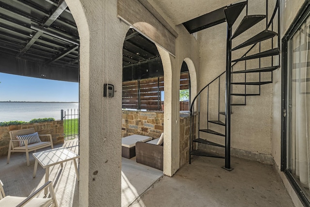 view of patio featuring a water view and stairs