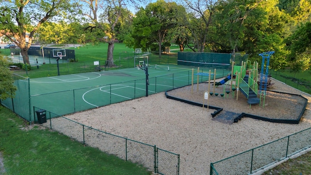 view of sport court with community basketball court, a lawn, fence, and playground community