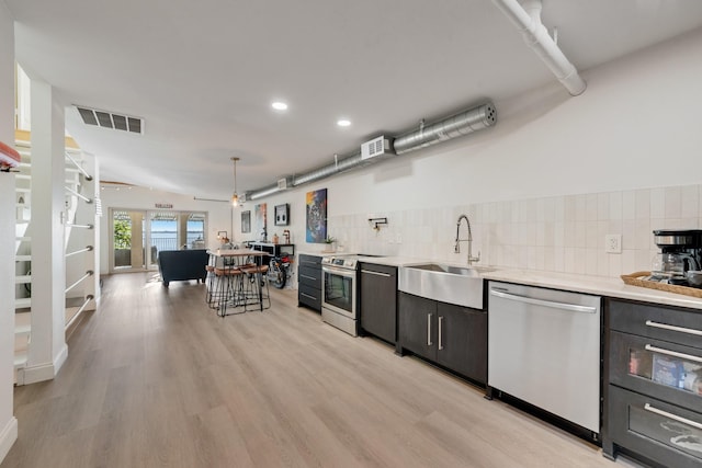 kitchen with recessed lighting, stainless steel appliances, light countertops, visible vents, and a sink