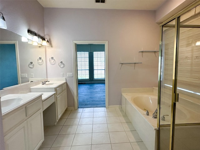 bathroom with a garden tub, tile patterned floors, a stall shower, baseboards, and two vanities