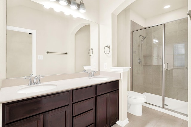 bathroom featuring tile patterned floors, a stall shower, toilet, and a sink