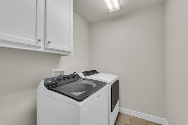 washroom with separate washer and dryer, baseboards, and cabinet space