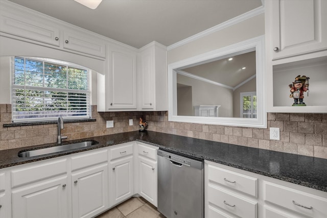 kitchen featuring white cabinets, stainless steel dishwasher, a sink, and tasteful backsplash