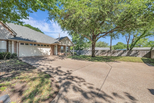 view of front of property with fence, a shingled roof, driveway, brick siding, and a garage