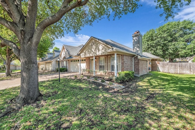 view of front of home with fence, concrete driveway, brick siding, a front yard, and a garage