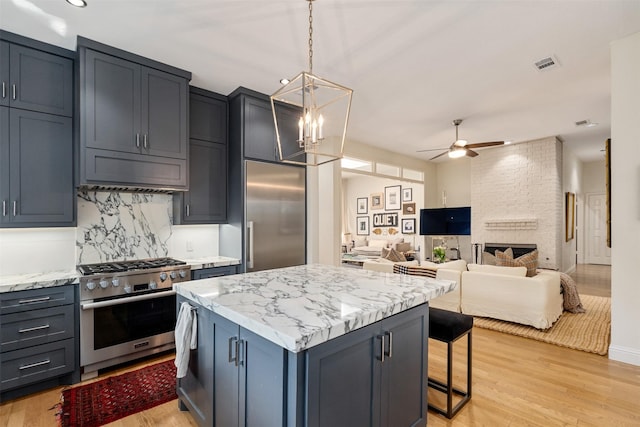 1747 Crescent Ln, Duncanville, TX 75137 - kitchen with high quality appliances, a ceiling fan, tasteful backsplash, a center island, and light wood-style flooring