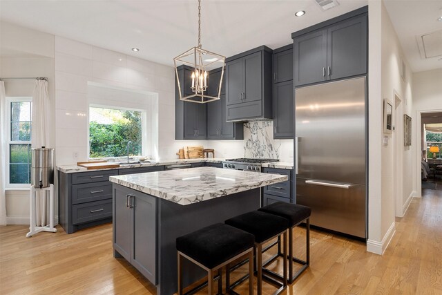 1747 Crescent Ln, Duncanville, TX 75137 - kitchen featuring appliances with stainless steel finishes, light wood-style flooring, a kitchen island, light stone countertops, and recessed lighting