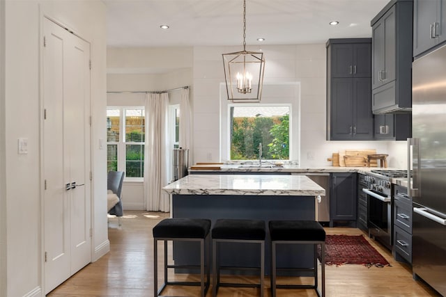 1747 Crescent Ln, Duncanville, TX 75137 - kitchen featuring high end appliances, light wood-style floors, a chandelier, a kitchen island, and recessed lighting