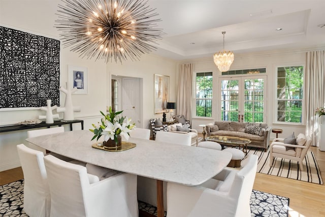 1747 Crescent Ln, Duncanville, TX 75137 - dining space featuring a chandelier, light wood-type flooring, a raised ceiling, and crown molding