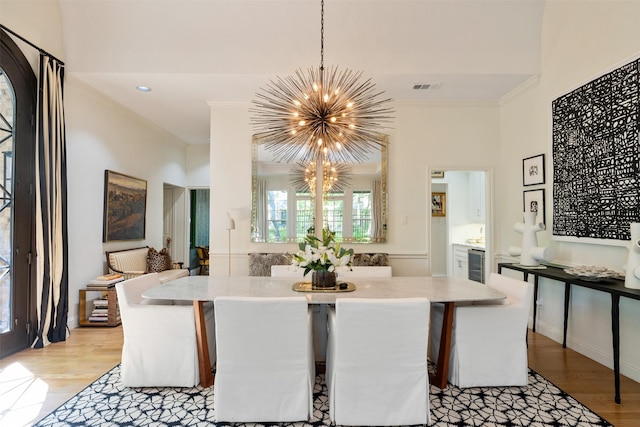 1747 Crescent Ln, Duncanville, TX 75137 - dining area featuring a chandelier, light wood-style flooring, crown molding, and wine cooler
