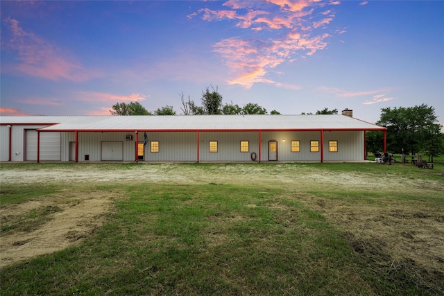 back of house with an outdoor structure, a pole building, a detached garage, and metal roof