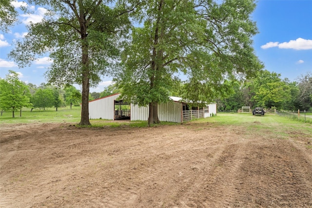 view of yard featuring an exterior structure, fence, and an outbuilding