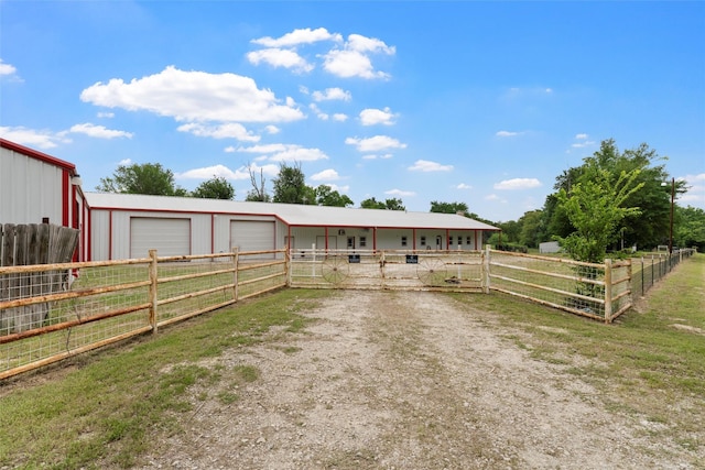 view of front of house with an exterior structure, a detached garage, an outbuilding, and driveway