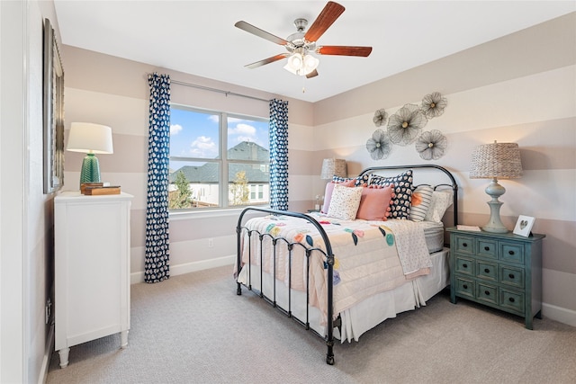 bedroom featuring baseboards, light colored carpet, and ceiling fan