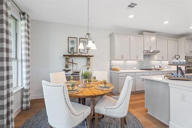 kitchen featuring light countertops, light wood-style flooring, backsplash, appliances with stainless steel finishes, and recessed lighting