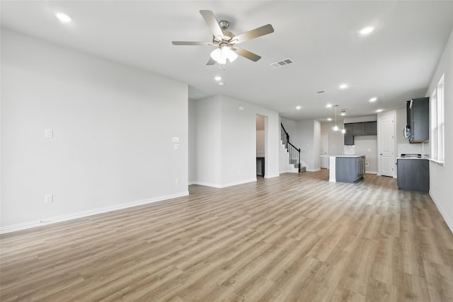 817 Hadley Dr, Princeton, TX 75071 - unfurnished living room with light wood-style floors, recessed lighting, stairs, and a ceiling fan