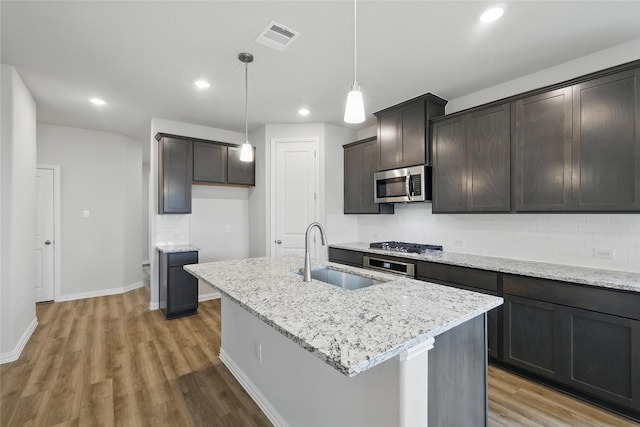 817 Hadley Dr, Princeton, TX 75071 - kitchen with stainless steel appliances, light wood-type flooring, light stone countertops, a kitchen island with sink, and recessed lighting