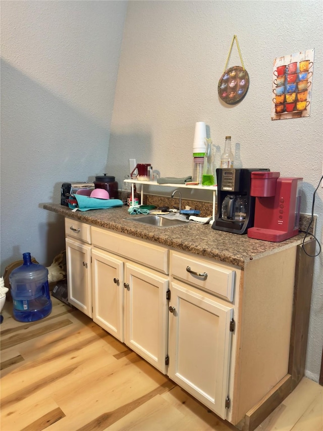 157 Business Blvd, Granbury, TX 76049 - kitchen featuring a sink, light wood-style floors, and a textured wall
