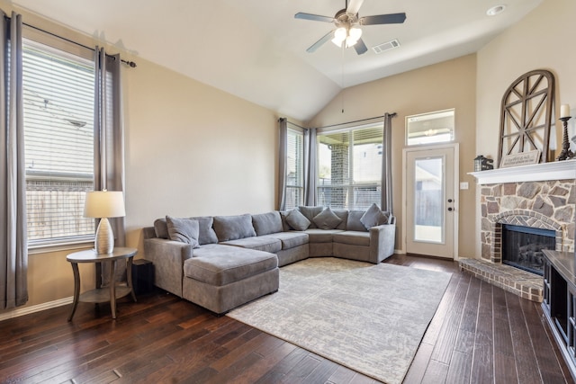 living room featuring ceiling fan, visible vents, a fireplace, lofted ceiling, and dark wood-style floors