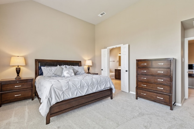 bedroom featuring visible vents, light colored carpet, ensuite bath, baseboards, and high vaulted ceiling