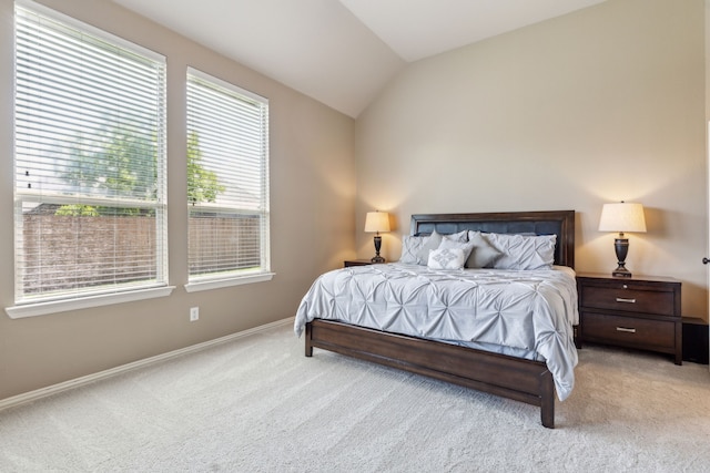 bedroom with carpet floors, vaulted ceiling, and baseboards