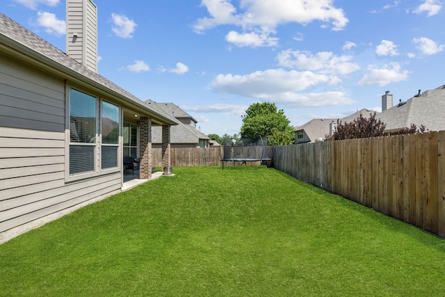 view of yard featuring a fenced backyard and a trampoline
