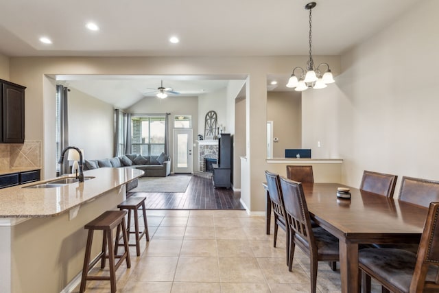 dining room with light tile patterned floors, baseboards, ceiling fan with notable chandelier, and recessed lighting
