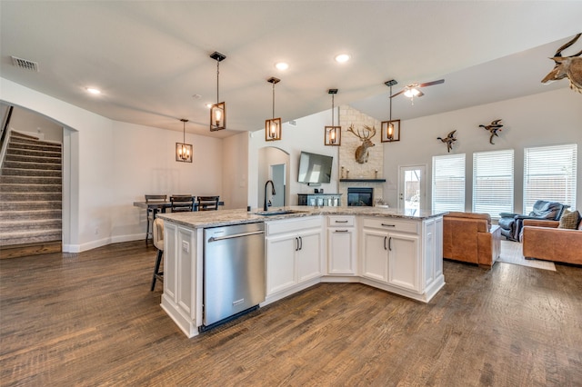 kitchen with stainless steel dishwasher, a sink, dark wood finished floors, open floor plan, and visible vents