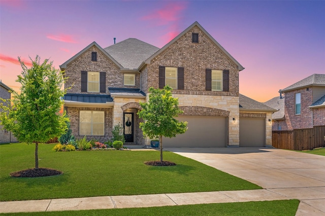 traditional home featuring brick siding, driveway, fence, and a lawn