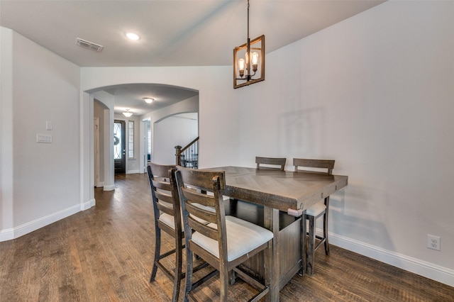 dining area with wood finished floors, visible vents, arched walkways, baseboards, and a chandelier