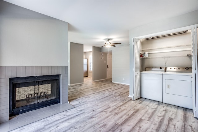 laundry area featuring washing machine and clothes dryer, light wood-style floors, laundry area, and ceiling fan