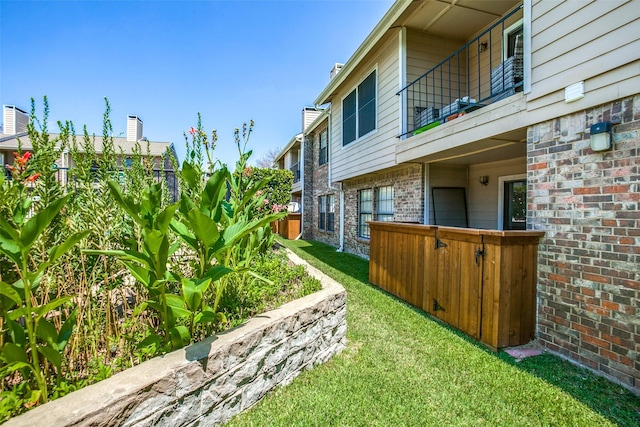 view of yard with fence and a balcony