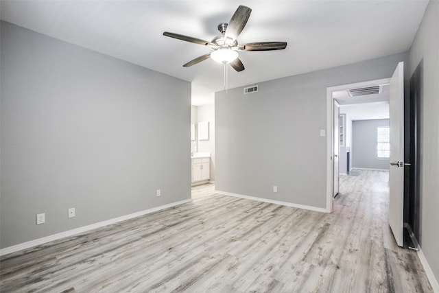 empty room featuring baseboards, a ceiling fan, visible vents, and light wood-style floors