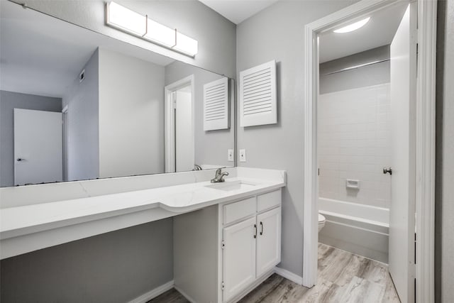 full bathroom featuring toilet, visible vents, shower / washtub combination, wood finished floors, and vanity