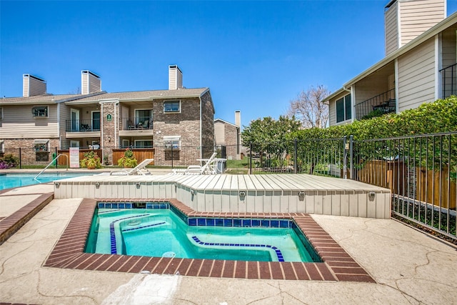 pool featuring fence, a community hot tub, and a patio