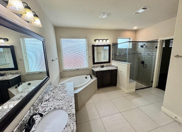 1005 Walford Dr, Forney, TX 75126 - full bathroom featuring two vanities, a shower stall, a garden tub, and tile patterned flooring