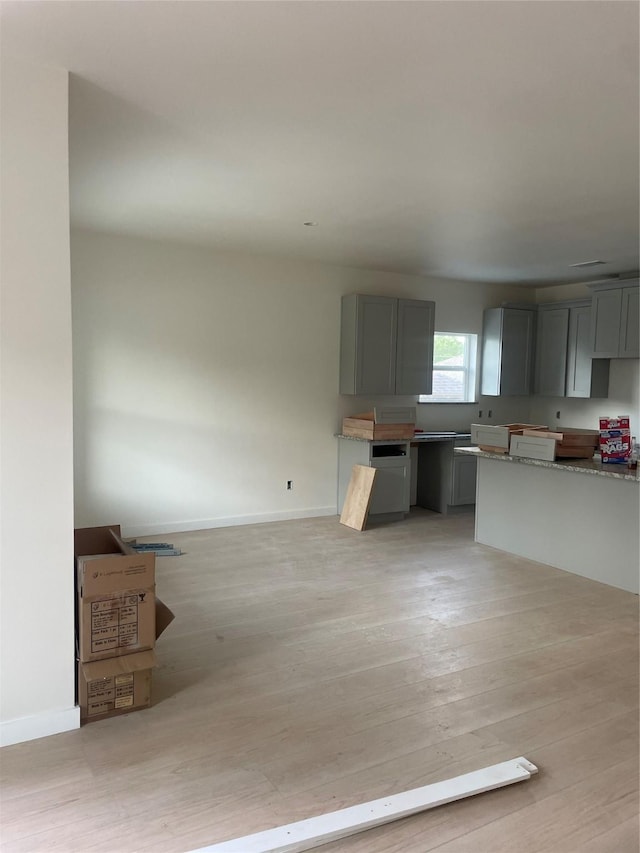 2510 Oxford Ave, Fort Worth, TX 76106 - kitchen featuring gray cabinets, light wood-style flooring, and baseboards