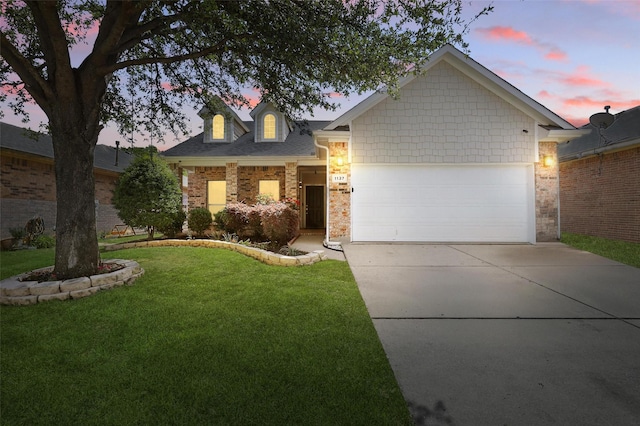 view of front of home with an attached garage, a lawn, and driveway