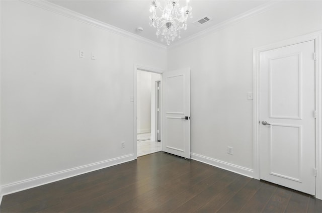 unfurnished room with dark wood-style flooring, baseboards, visible vents, an inviting chandelier, and ornamental molding