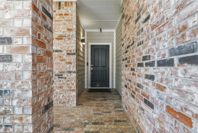 doorway to property with brick siding