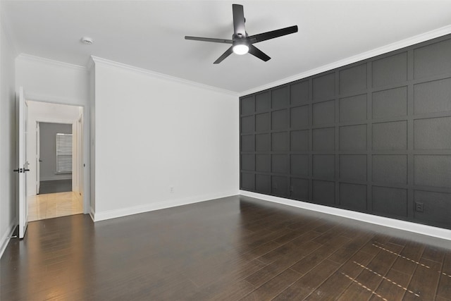 empty room with ceiling fan, a decorative wall, ornamental molding, and dark wood-style flooring