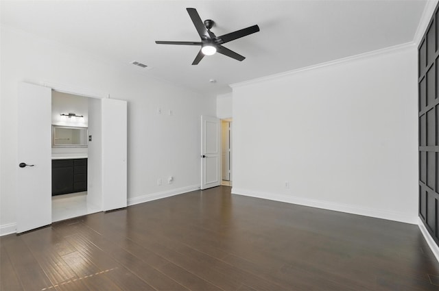unfurnished bedroom featuring baseboards, crown molding, dark wood-type flooring, and visible vents