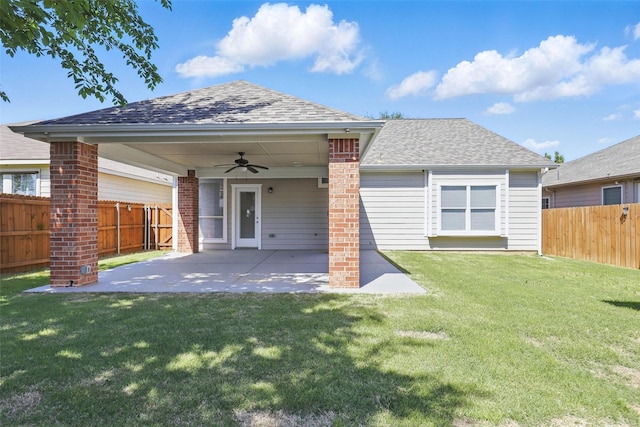 rear view of house with a lawn, ceiling fan, a fenced backyard, and a patio area