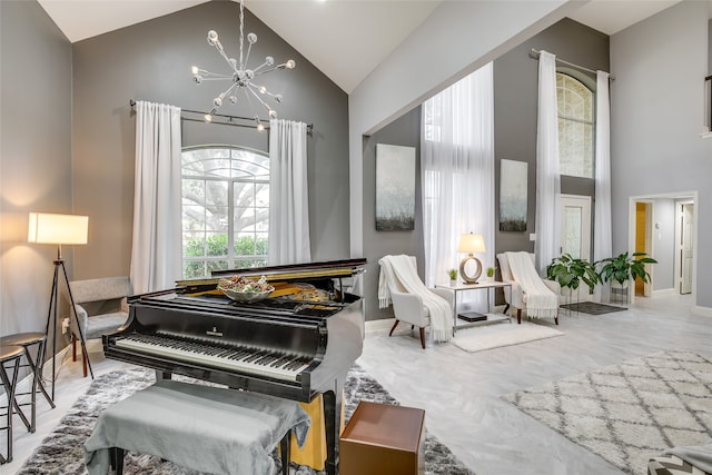 living area with high vaulted ceiling, a chandelier, and baseboards